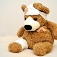 A teddy bear with bandages on.