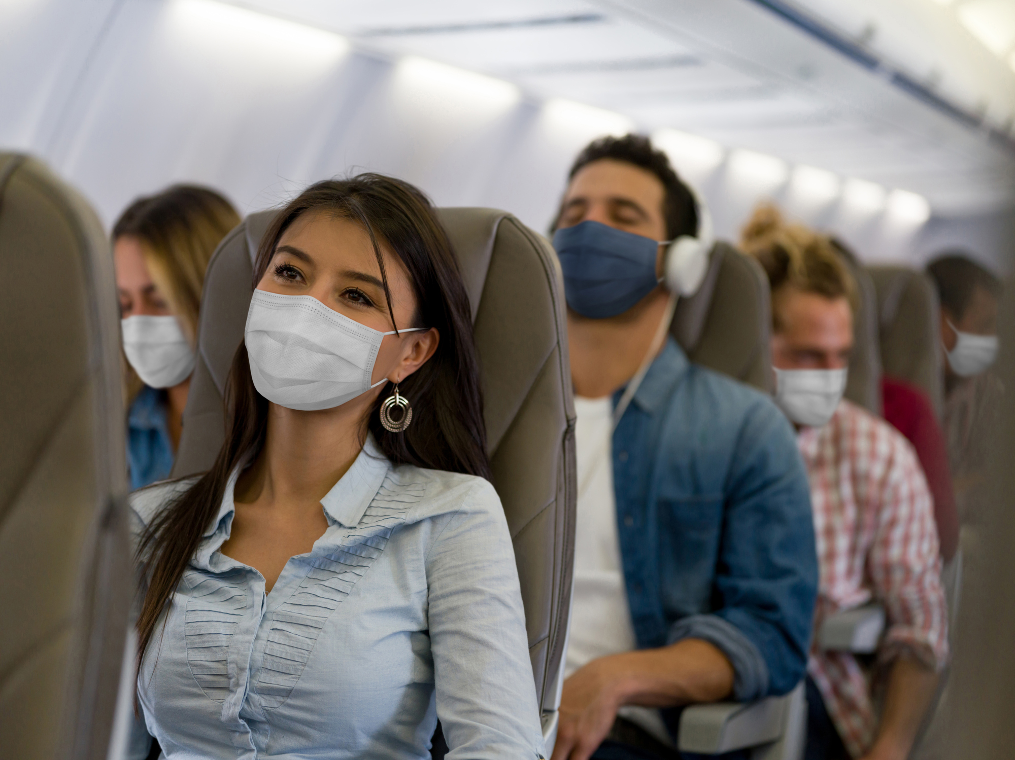 People with masks on on a plane.