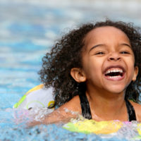 A smiling girl in a pool.
