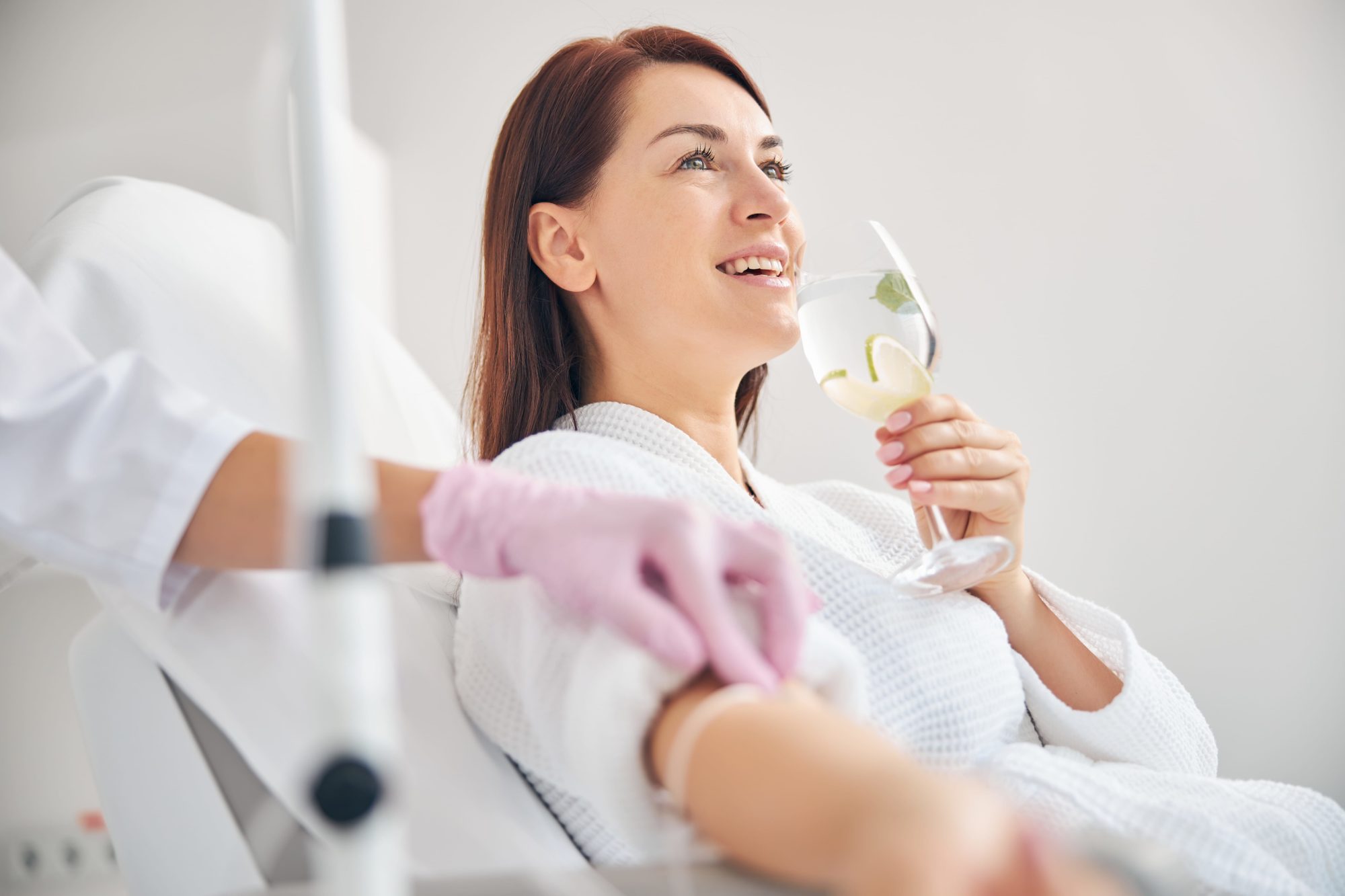 Woman smiling while getting IV therapy.